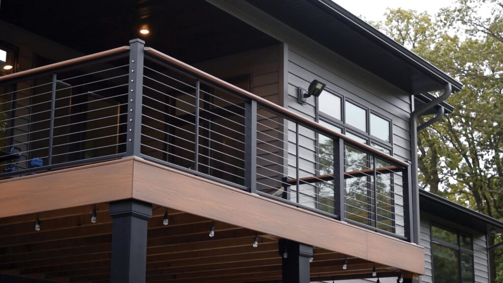 AFCO Series 275 aluminum railing with horizontal cable infill and a wood top rail on a modern elevated deck.