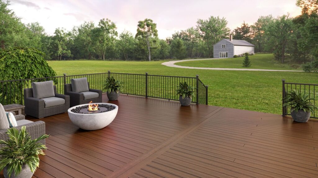Black Envision Fairway modern aluminum railing around a mahogany-toned composite deck with a fire bowl.