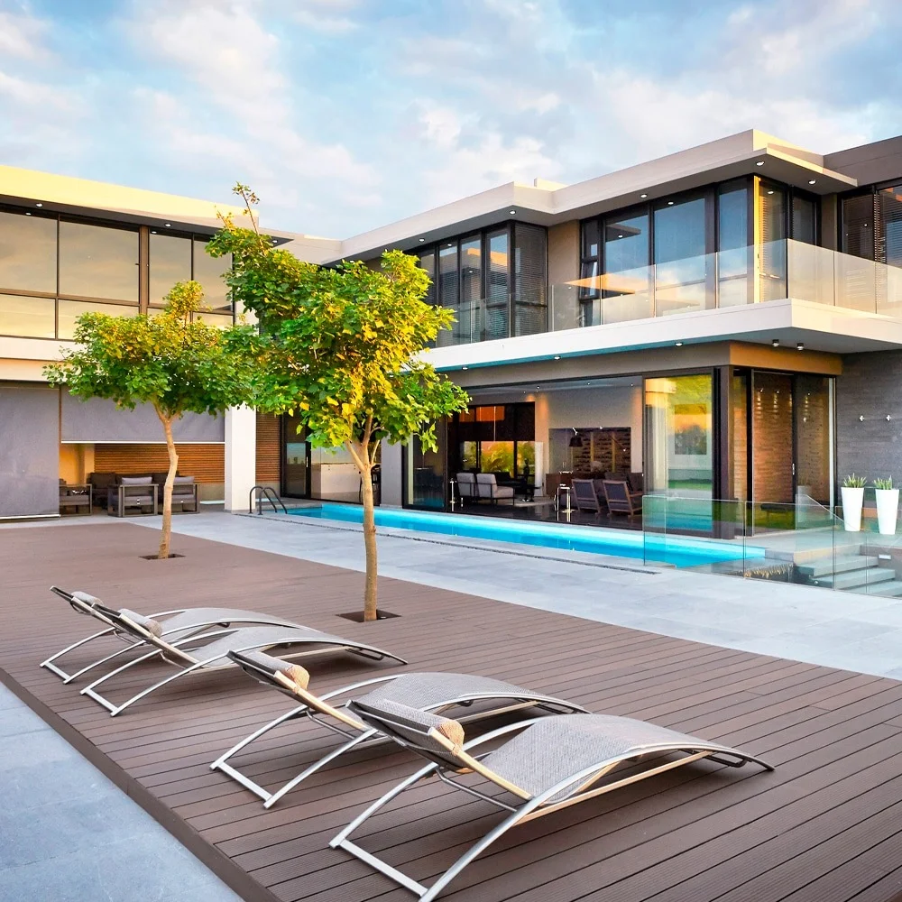 Eva-Last bamboo composite decking in warm brown beside a pool at a modern glass-walled home