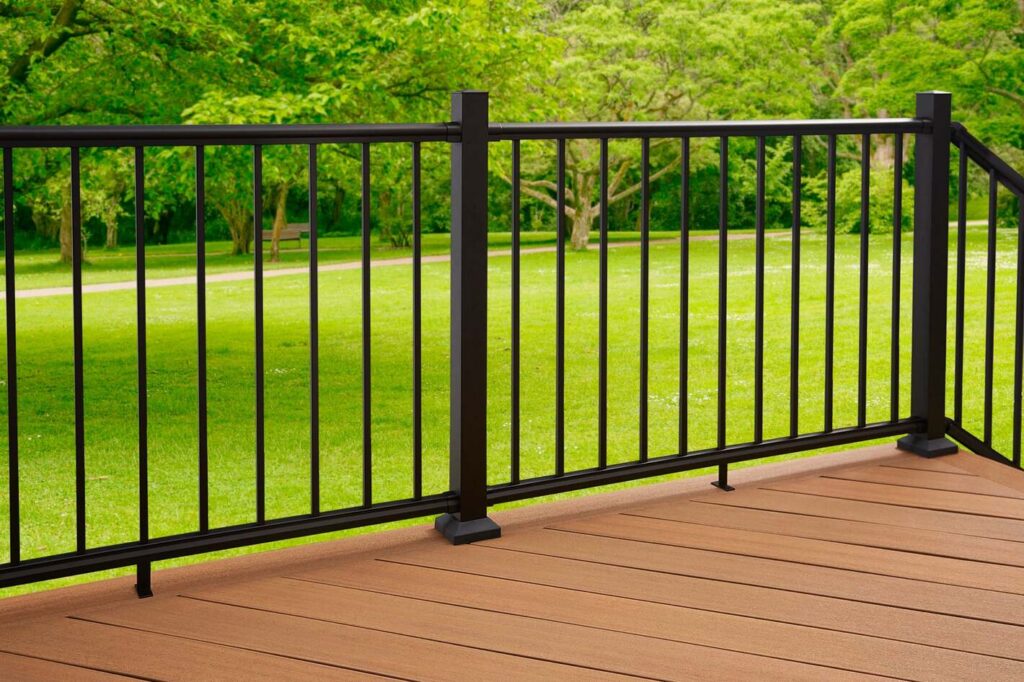 Close-up of black Fiberon CitySide aluminum railing on a cedar-toned composite deck, simple metal deck railing ideas.