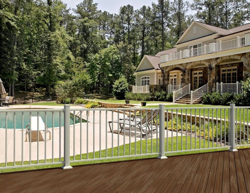 White Fortress AL13 aluminum railing between a dark brown deck and a pool deck.