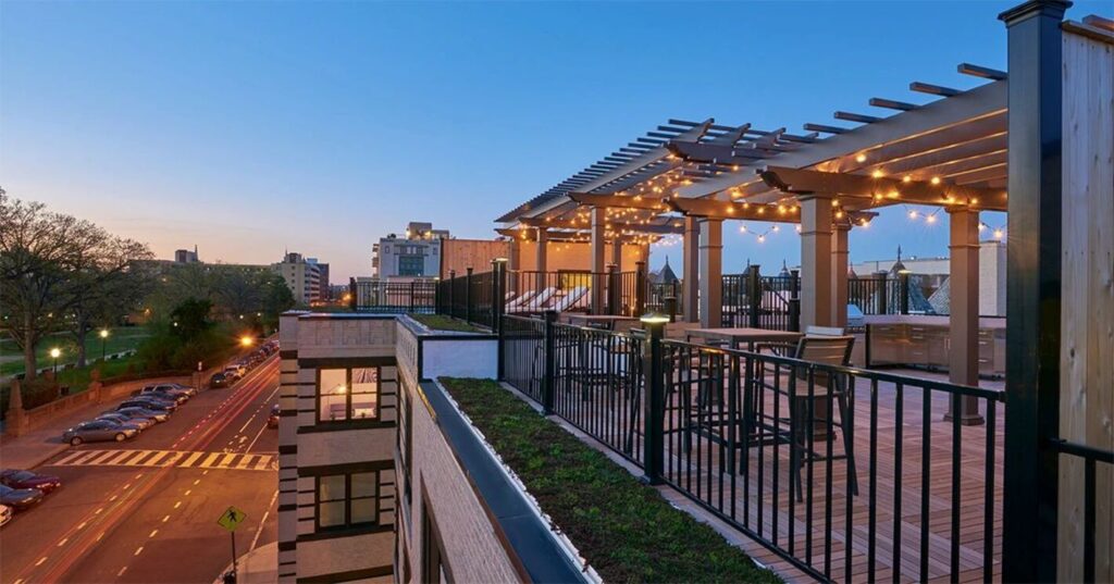 Fortress FE26 Plus black steel railing around an urban rooftop deck with a pergola.