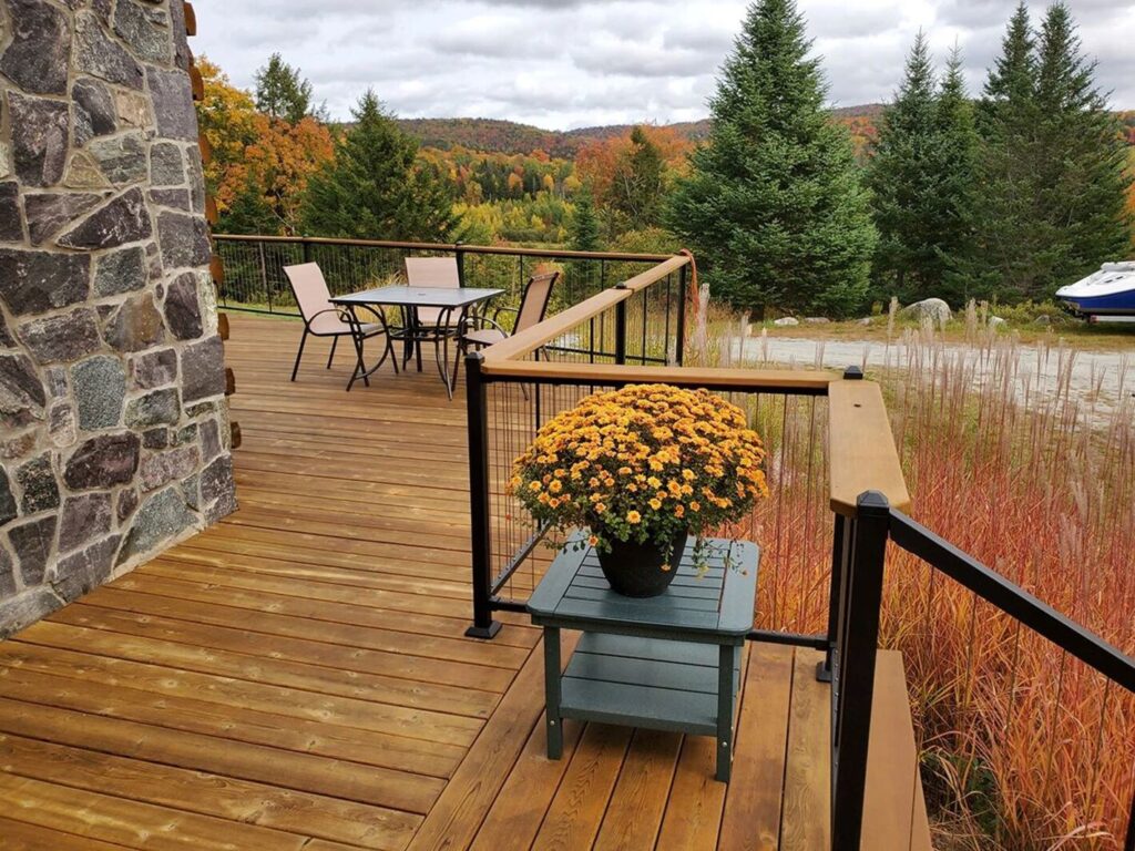 Fortress Cable V-Series black steel railing with vertical cable on a wood deck in fall.