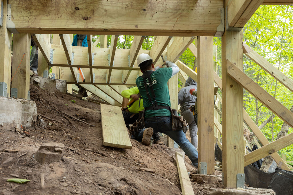 ProWood treated joists braced on a hillside deck frame with galvanized post bases.