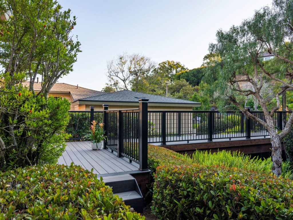 Black TimberTech Impression Rail Express railing with Ashwood drink rail beside a bistro table.