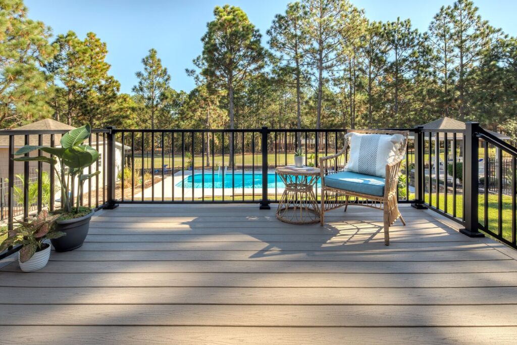Trex Signature black aluminum railing with square balusters beside a pool, classic metal deck railing ideas.