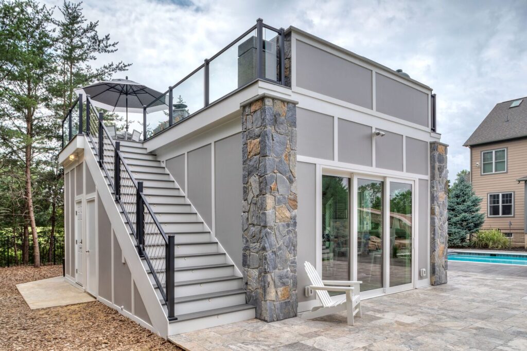 Trex Signature railing on a pool house rooftop deck with a slim cable stair rail, elevated metal deck railing ideas.