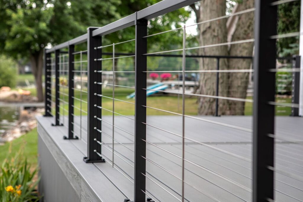 Trex Signature X-Series cable railing with stainless cable and black posts on a gray composite lake deck, horizontal metal deck railing ideas.