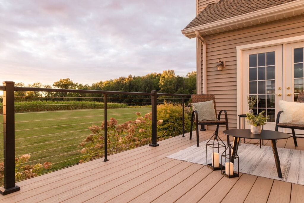 Westbury Bella Cavo horizontal cable metal deck railing ideas on a gray composite deck with a hilltop sunset view.