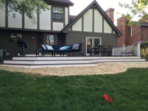 Two-tone composite deck in Wheaton, IL with dark picture-frame border and mitred corner steps.