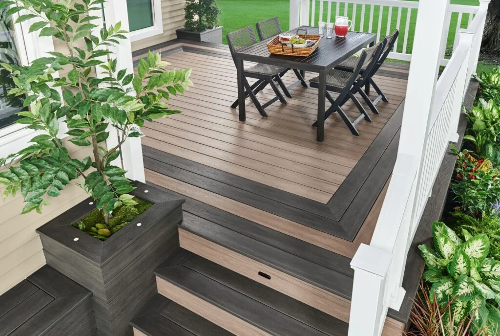 Wolf composite decking in gray and brown with a picture-frame border, stairs and a built-in planter