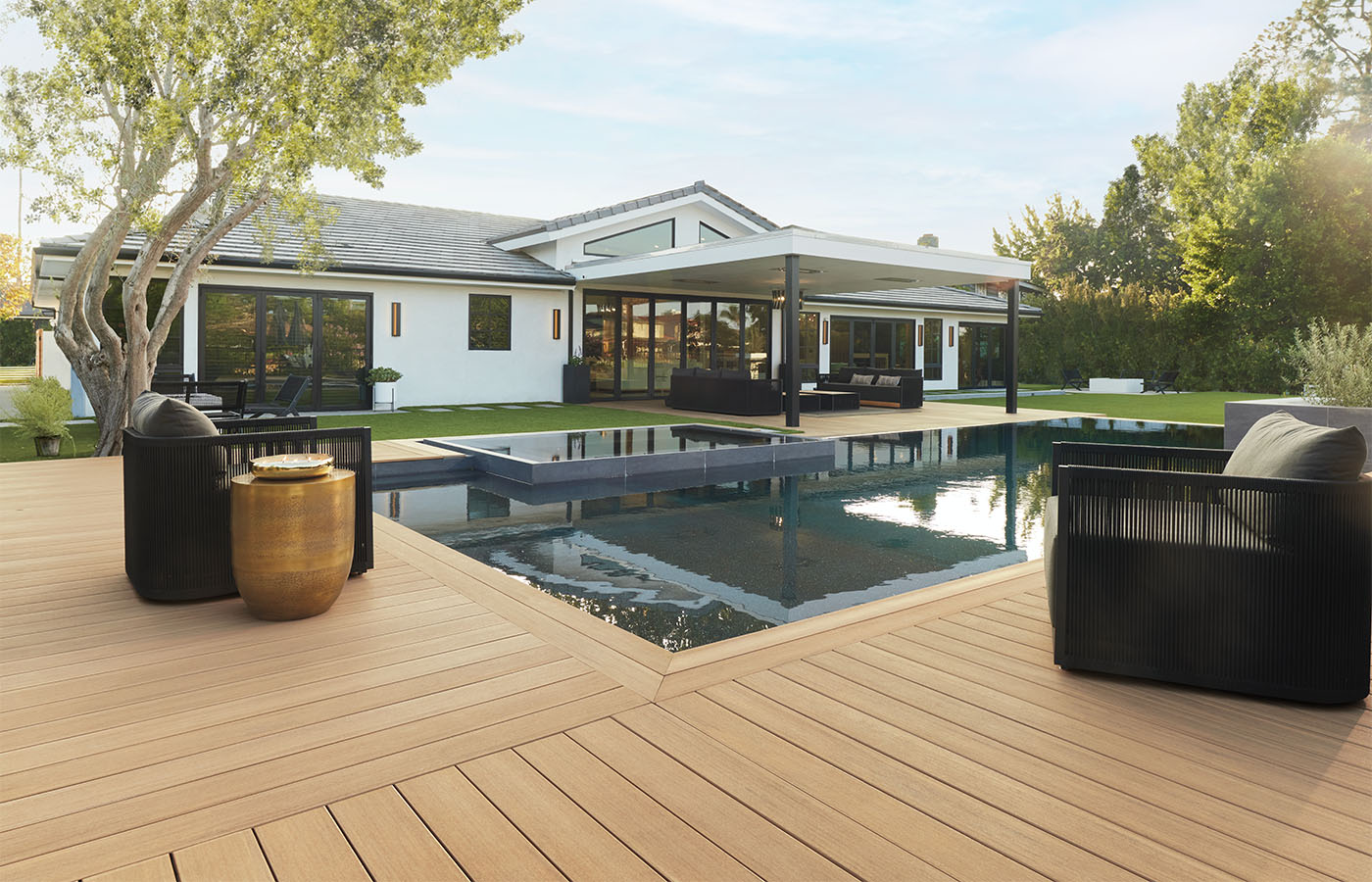 Capped composite decking around a modern backyard pool and covered patio