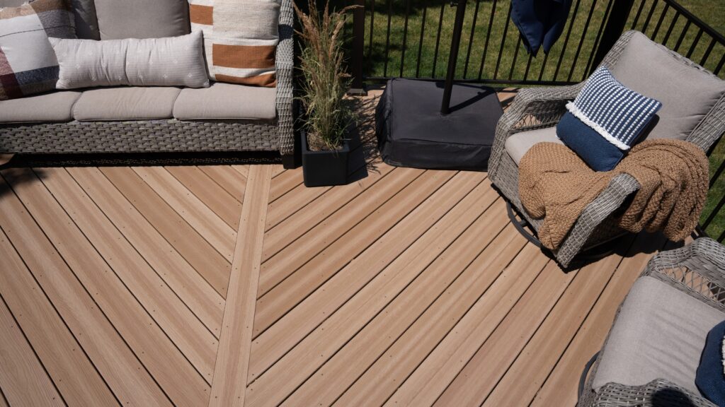 Envision Distinction Hampton Dunes deck with diagonal board layout, center divider, black railing, and outdoor lounge furniture.