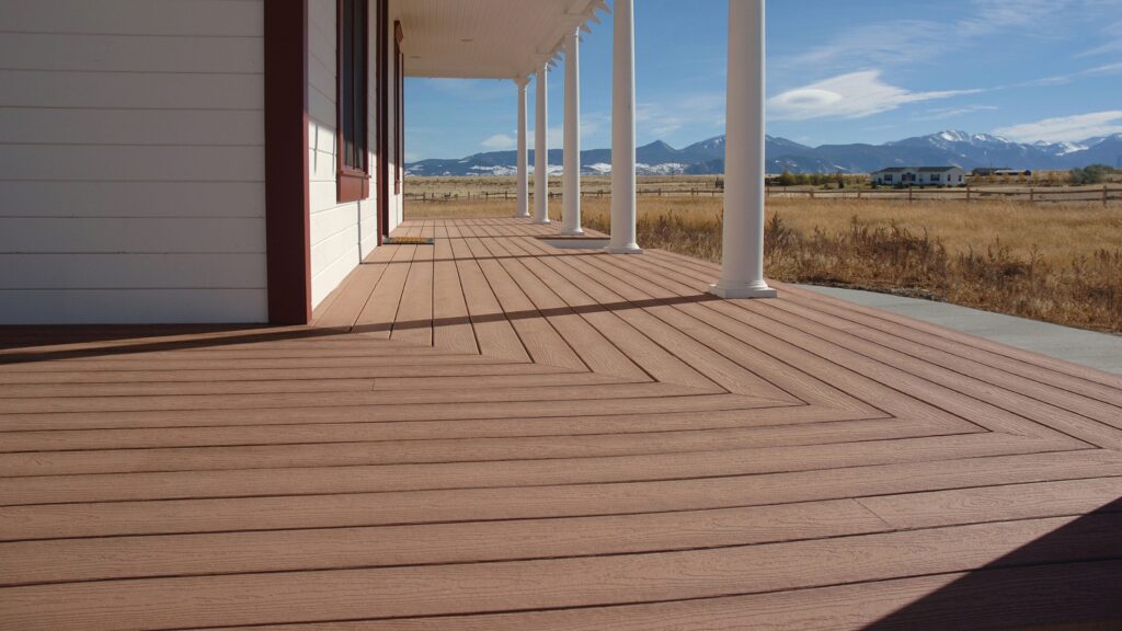 Envision EverGrain Redwood porch with white columns, open countryside, and distant snow-capped mountain views.