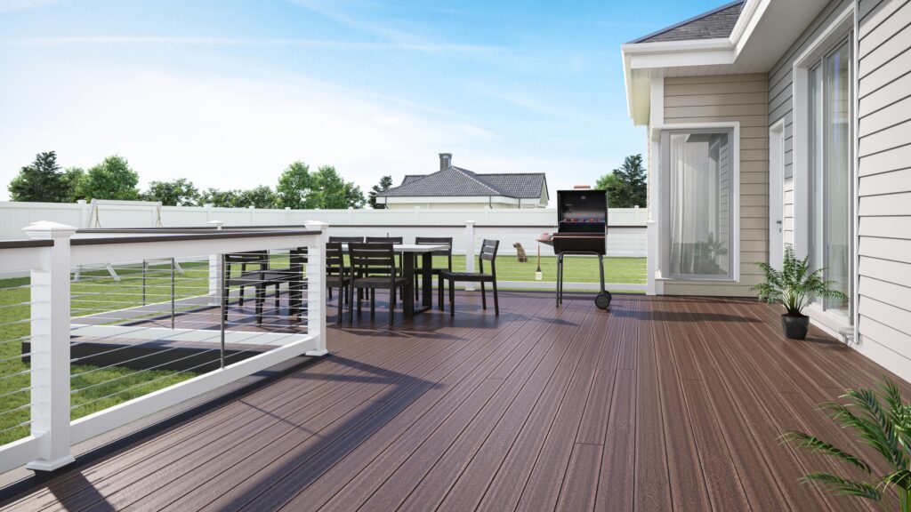 Envision Ridge Premium Black Walnut deck with white posts, horizontal cable railing, outdoor dining table, and grill.