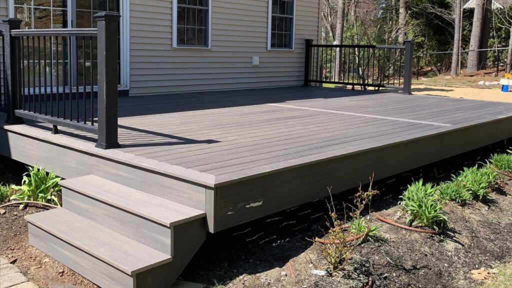 Fiberon deck ideas featuring Concordia Symmetry Graphite Decking with Black Railing and contrasting board pattern.