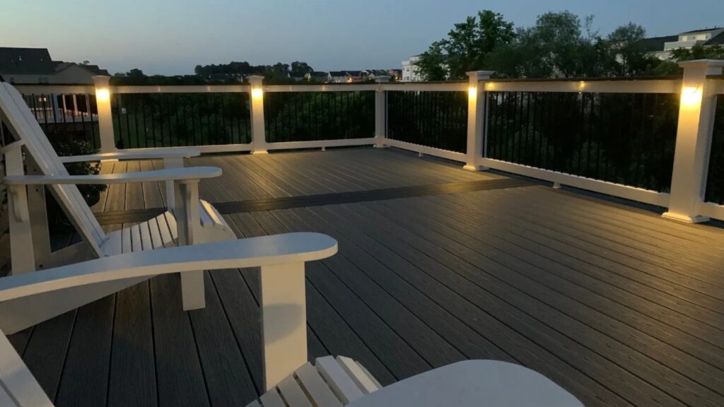 Fiberon Good Life Beach House deck with warm post lighting, white railing, and black balusters.