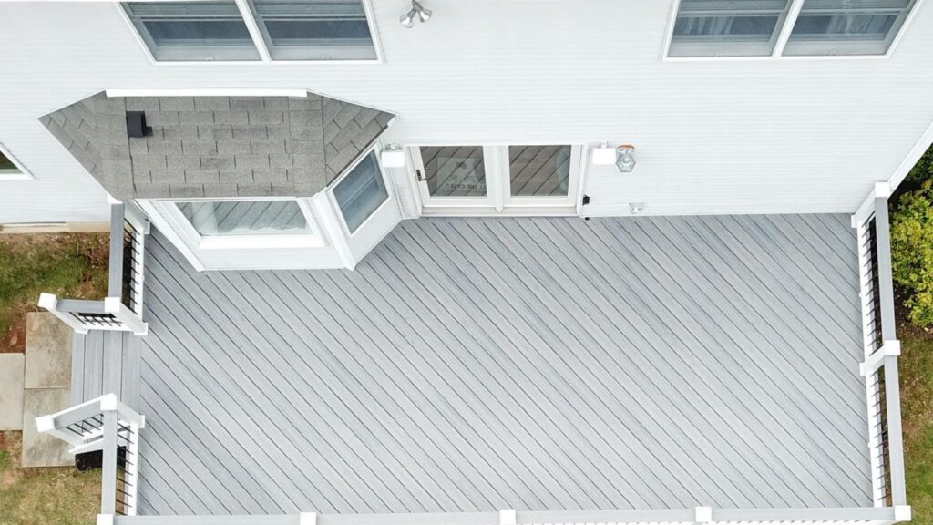Fiberon deck ideas featuring Good Life Beach House gray decking with white posts and dark balusters.