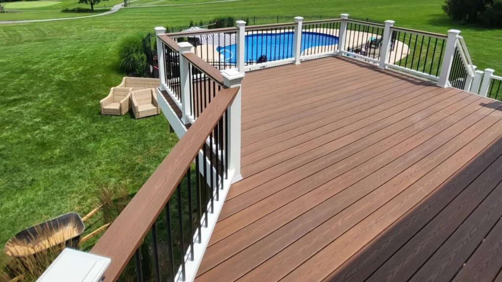 Fiberon Good Life Bungalow deck with white and black railing overlooking a backyard swimming pool.