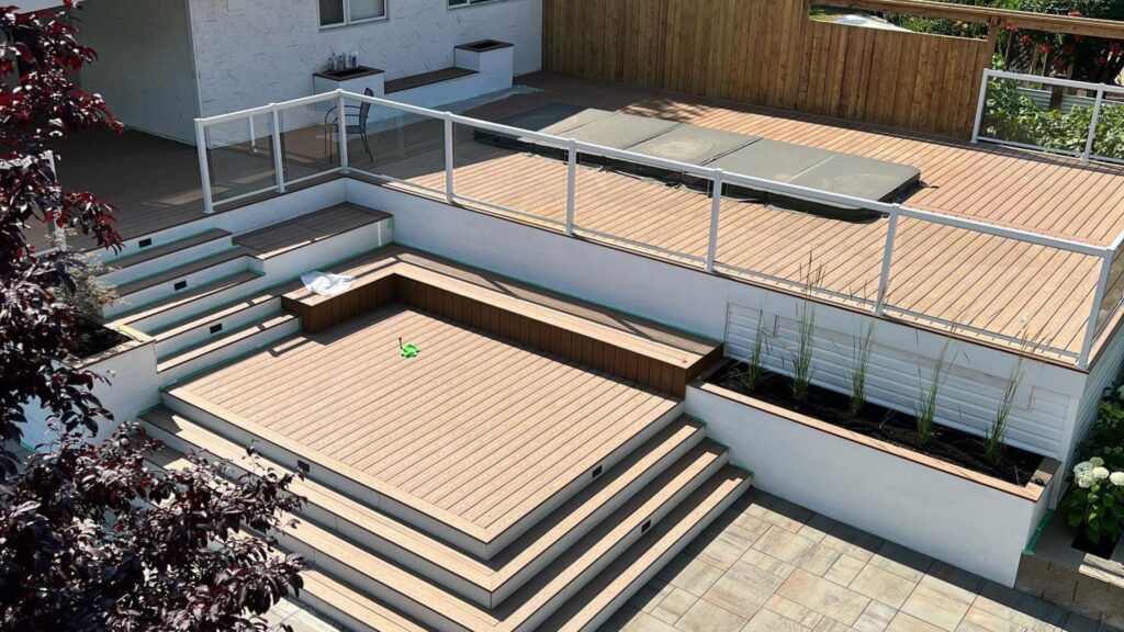 Fiberon Good Life Tuscan Villa deck with white-framed glass railing and multi-level outdoor living space.