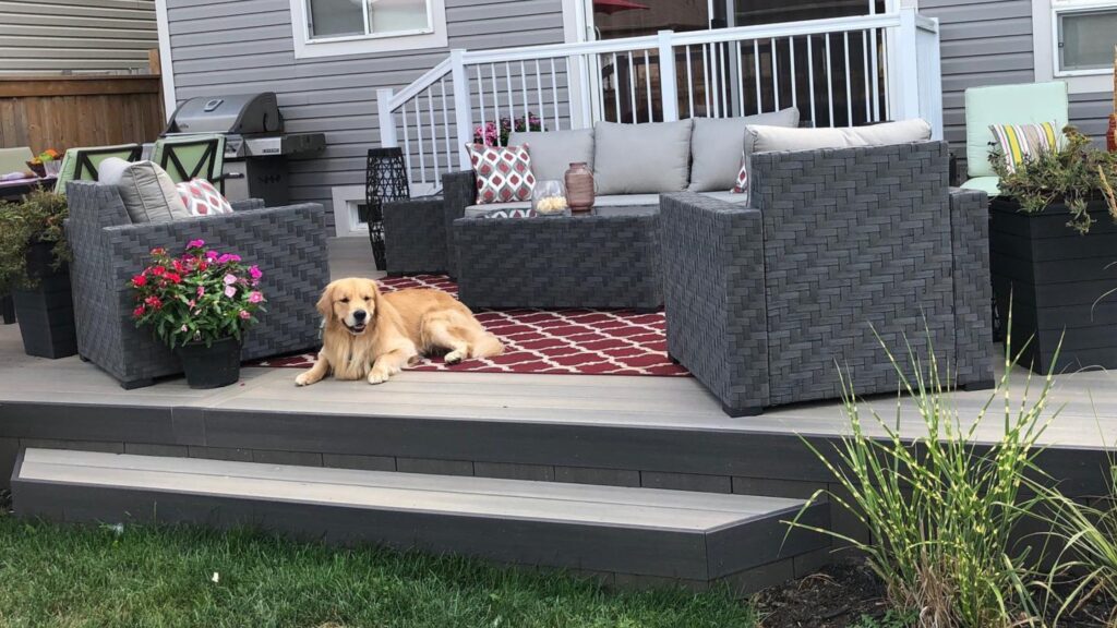 Fiberon deck ideas featuring Paramount Sandstone PVC decking with dark fascia, lounge furniture, grill, and backyard seating.