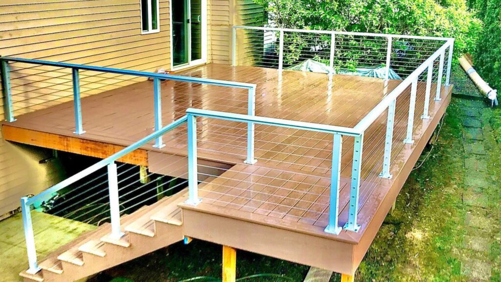 Fiberon Promenade Sandy Pier PVC deck with horizontal cable railing, metal posts, and outdoor stairs.