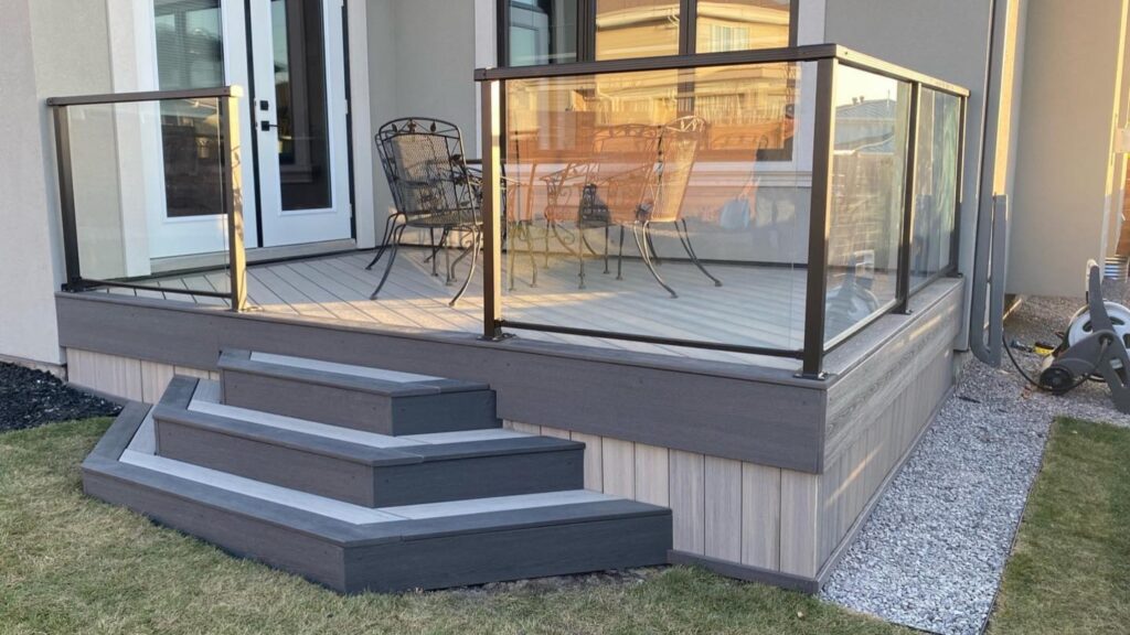 Fiberon deck ideas featuring Sanctuary Earl Grey and Chai decking with black-framed glass railing and tiered steps.