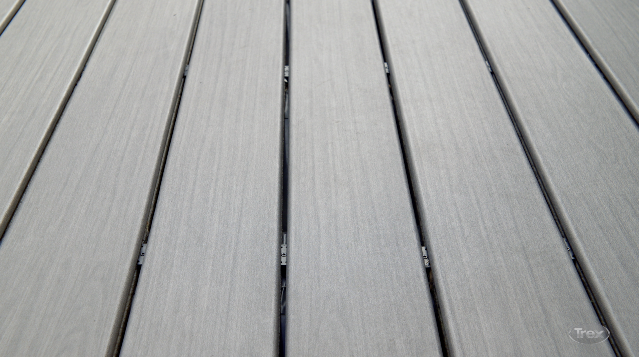 Trex hidden fastener clips creating consistent gaps between composite deck boards.