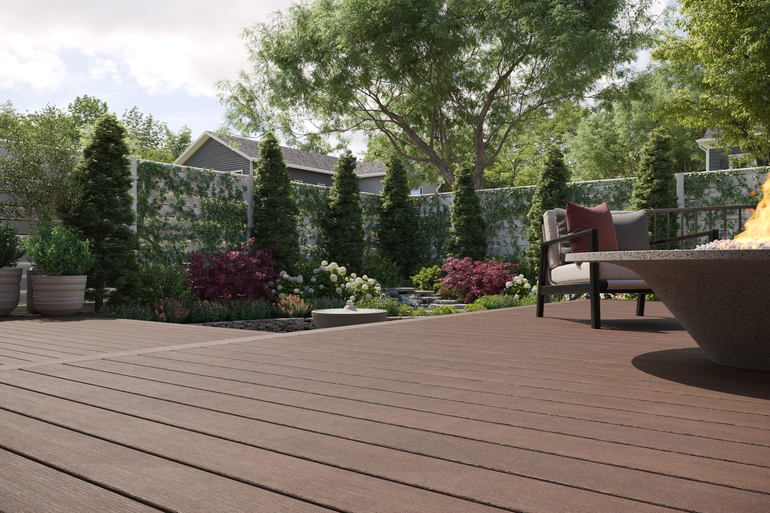 Brown composite deck with picture-frame boards, garden landscaping, and outdoor seating