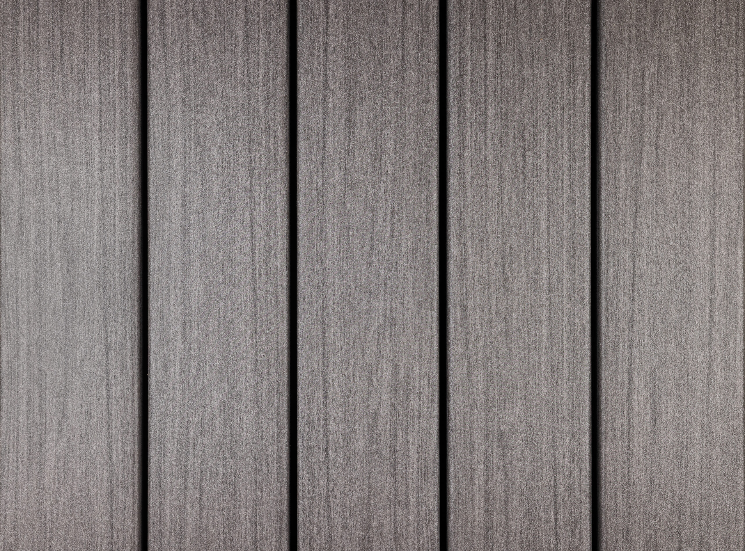 Proper deck board spacing shown between evenly installed composite decking boards.